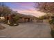 Stunning home exterior featuring a long driveway and a beautiful garden with blooming flowers, plus a large garage at 10886 E Ludlow Dr, Scottsdale, AZ 85255