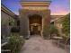 Beautiful home with an arched entry covered in lush bougainvillea, desert landscaping and a tranquil waterfall at 10886 E Ludlow Dr, Scottsdale, AZ 85255