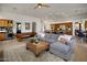 Open-concept living room with pool table, grey sofa, and a kitchen area at 10886 E Ludlow Dr, Scottsdale, AZ 85255