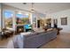 Spacious living room with a fireplace, pool table, comfortable grey sofa and a ceiling fan at 10886 E Ludlow Dr, Scottsdale, AZ 85255