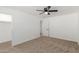 Bright bedroom featuring neutral carpet, a ceiling fan and an open closet for storage at 12207 N Escobar Way, Phoenix, AZ 85022