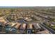 An aerial view of a desert community and roundabout, showing the houses, landscaping and mountains at 12924 W Caraveo Pl, Peoria, AZ 85383