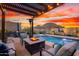 Relaxing backyard with a sparkling pool, hot tub, fire pit, and comfortable seating area under pergola at 12924 W Caraveo Pl, Peoria, AZ 85383