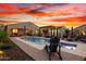 Stunning backyard featuring a large pool, spa, outdoor seating, lush landscaping, and a cozy fire pit at 12924 W Caraveo Pl, Peoria, AZ 85383