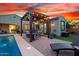 Inviting backyard with a sparkling pool, pergola with lights, and cozy seating area for outdoor enjoyment at 12924 W Caraveo Pl, Peoria, AZ 85383