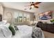 Well-lit bedroom with a decorative wall and large mounted television at 12924 W Caraveo Pl, Peoria, AZ 85383