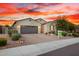 Beautiful single-story home with a two-car garage, desert landscaping, and a welcoming entrance at sunset at 12924 W Caraveo Pl, Peoria, AZ 85383