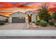 Well-maintained home with a two-car garage, desert landscaping, and a brick driveway leading to the entrance at 12924 W Caraveo Pl, Peoria, AZ 85383