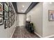 Inviting hallway featuring wood floors, a stylish console table, and a gallery wall of framed photos at 12924 W Caraveo Pl, Peoria, AZ 85383