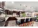 Modern kitchen featuring dark wood cabinets, granite countertops, and a large center island with seating at 12924 W Caraveo Pl, Peoria, AZ 85383
