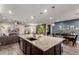 Spacious kitchen with a large granite island, dark wood cabinets, and an open layout connecting to the living areas at 12924 W Caraveo Pl, Peoria, AZ 85383
