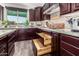 Well-organized kitchen drawers, granite countertops, and classic wooden cabinets with a view to the backyard at 12924 W Caraveo Pl, Peoria, AZ 85383