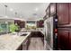 Bright kitchen with granite countertops, dark wood cabinetry, and stainless steel appliances at 12924 W Caraveo Pl, Peoria, AZ 85383
