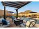 Stunning outdoor space showcasing a pool with fountains, a cozy pergola, and inviting patio furniture around a fire pit at 12924 W Caraveo Pl, Peoria, AZ 85383