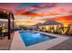 Backyard pool with mountain views, featuring water features and lush landscaping at 12924 W Caraveo Pl, Peoria, AZ 85383