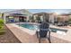 Resort-style backyard with a sparkling pool, water features, a cozy lounge area, and ample patio seating at 12924 W Caraveo Pl, Peoria, AZ 85383