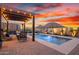 Scenic backyard with a pool, spa, and outdoor seating, set against a backdrop of desert mountains at 12924 W Caraveo Pl, Peoria, AZ 85383