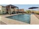 Inviting backyard pool with a pergola-covered lounge area and desert views beyond the secure fence at 12924 W Caraveo Pl, Peoria, AZ 85383