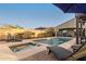 Beautiful backyard with a sparkling pool, a spa, chaise lounges, and a well-maintained patio with desert landscaping at 12924 W Caraveo Pl, Peoria, AZ 85383