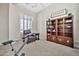 Bedroom showcasing a large window with shutters, exercise equipment, and a wooden bookcase at 1320 W Whitman Dr, Anthem, AZ 85086