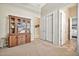 Hallway with built-in cabinet and access to multiple rooms with neutral carpeting at 1320 W Whitman Dr, Anthem, AZ 85086