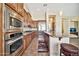 Modern kitchen with stainless steel appliances, wooden cabinets, and a granite-topped breakfast bar at 1320 W Whitman Dr, Anthem, AZ 85086