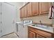 Functional laundry room equipped with washer, dryer, sink, and ample cabinet space at 1320 W Whitman Dr, Anthem, AZ 85086