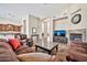 Spacious living room featuring leather furniture, a decorative fireplace, and a view of the kitchen area at 1320 W Whitman Dr, Anthem, AZ 85086