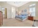 Bright bedroom with neutral carpet and a queen bed with blue patterned bedding at 1320 W Whitman Dr, Anthem, AZ 85086