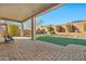Large covered patio with brick floor and well-maintained artificial turf at 1320 W Whitman Dr, Anthem, AZ 85086