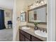 Bathroom featuring double sinks with granite counters, decorative lights, and a large mirror at 13221 N 17Th Pl, Phoenix, AZ 85022