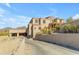 A long driveway leads up to this stucco home with a three-car garage and front entryway at 13221 N 17Th Pl, Phoenix, AZ 85022