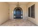 Elegant front entrance with an arched black door, welcome mat, and chandelier at 13221 N 17Th Pl, Phoenix, AZ 85022