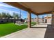 A covered patio that leads to a pristine backyard with synthetic grass and a conversation area at 1329 W Crape Rd, Queen Creek, AZ 85140