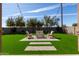 A pristine backyard with artificial turf, a paved walkway, and a conversation set at 1329 W Crape Rd, Queen Creek, AZ 85140
