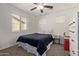 This bedroom features neutral walls, a ceiling fan, carpet, and a black quilt covering the bed at 1329 W Crape Rd, Queen Creek, AZ 85140