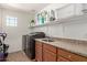 A bright laundry room with modern appliances, a utility sink, and ample storage space at 1329 W Crape Rd, Queen Creek, AZ 85140