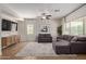 Bright living room featuring tile floors, a ceiling fan, and a comfortable gray sectional sofa with natural light at 1329 W Crape Rd, Queen Creek, AZ 85140
