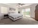Bright bedroom featuring a sliding glass door, ceiling fan, and carpeted floors at 1329 W Crape Rd, Queen Creek, AZ 85140