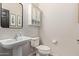 Cozy powder room featuring a pedestal sink, framed mirror, and convenient wall cabinet at 1329 W Crape Rd, Queen Creek, AZ 85140