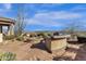 Inviting backyard featuring a built-in grill, stone fire pit, and professionally landscaped desert-scape at 13827 N Sunset Dr, Fountain Hills, AZ 85268