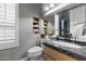 Well-lit bathroom with granite countertop, decorative mirror, and ample storage at 13827 N Sunset Dr, Fountain Hills, AZ 85268