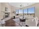 Bright living room with large windows, a fireplace, stylish seating, and a scenic outdoor view at 13827 N Sunset Dr, Fountain Hills, AZ 85268