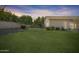 The backyard features a large grassy area and desert landscaping, set against a blue twilight sky at 14955 N 78Th Dr, Peoria, AZ 85381