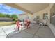 Covered patio features a concrete floor, and a red plastic table and chairs at 14955 N 78Th Dr, Peoria, AZ 85381