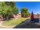 Backyard featuring lush lawn and mature trees providing shade for outdoor activities at 16966 W Rio Vista Ln, Goodyear, AZ 85338