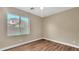 Simple bedroom featuring hardwood floors, a ceiling fan, and a bright window at 16966 W Rio Vista Ln, Goodyear, AZ 85338