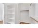 Bright walk-in closet featuring custom white shelving and wooden clothes rods for storage at 16966 W Rio Vista Ln, Goodyear, AZ 85338