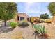 Landscaped backyard featuring desert vegetation and a covered patio area at 17204 W Cordova Ct, Surprise, AZ 85387