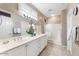 Bathroom featuring double sinks, large mirror, neutral tile floor, and glass-enclosed shower at 17204 W Cordova Ct, Surprise, AZ 85387